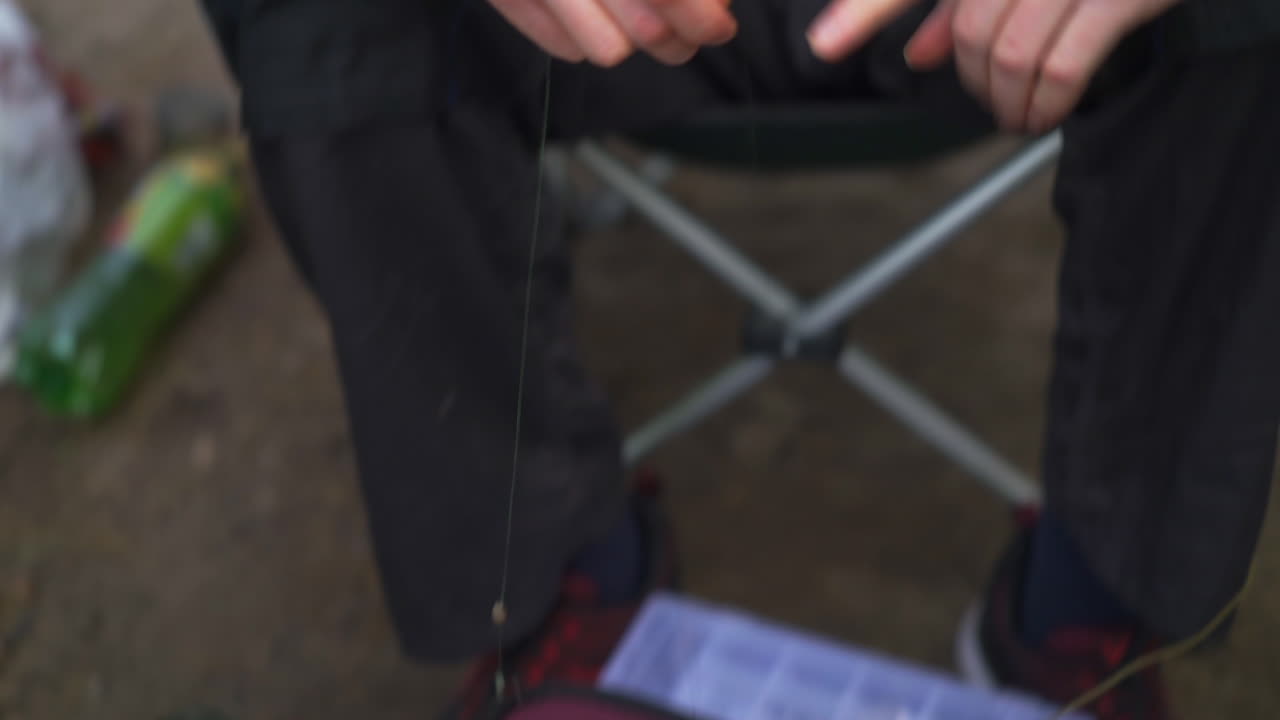 pescador preparando sedal y cebo