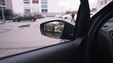 car side mirror view of parking lot