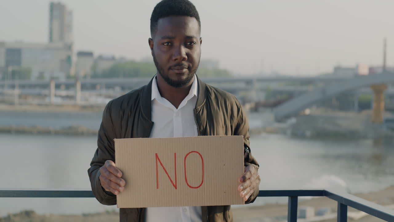 Man Holding a "No" Sign