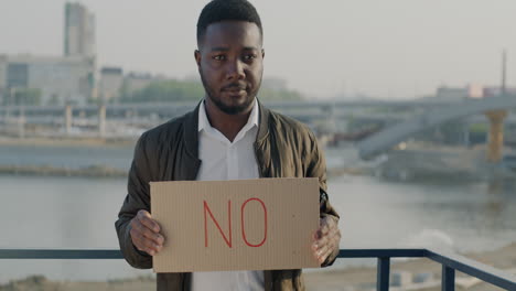 man holding a "no" sign