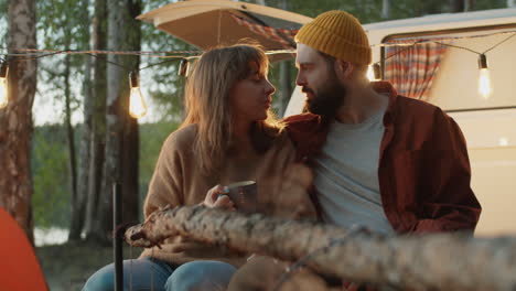 romantic couple bonding by campfire in evening