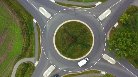 abstract view vertically from above on a small traffic circle with a green traffic island in the center