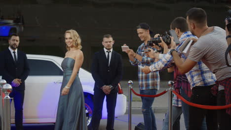 celebrity arriving at a red carpet event with paparazzi and fans