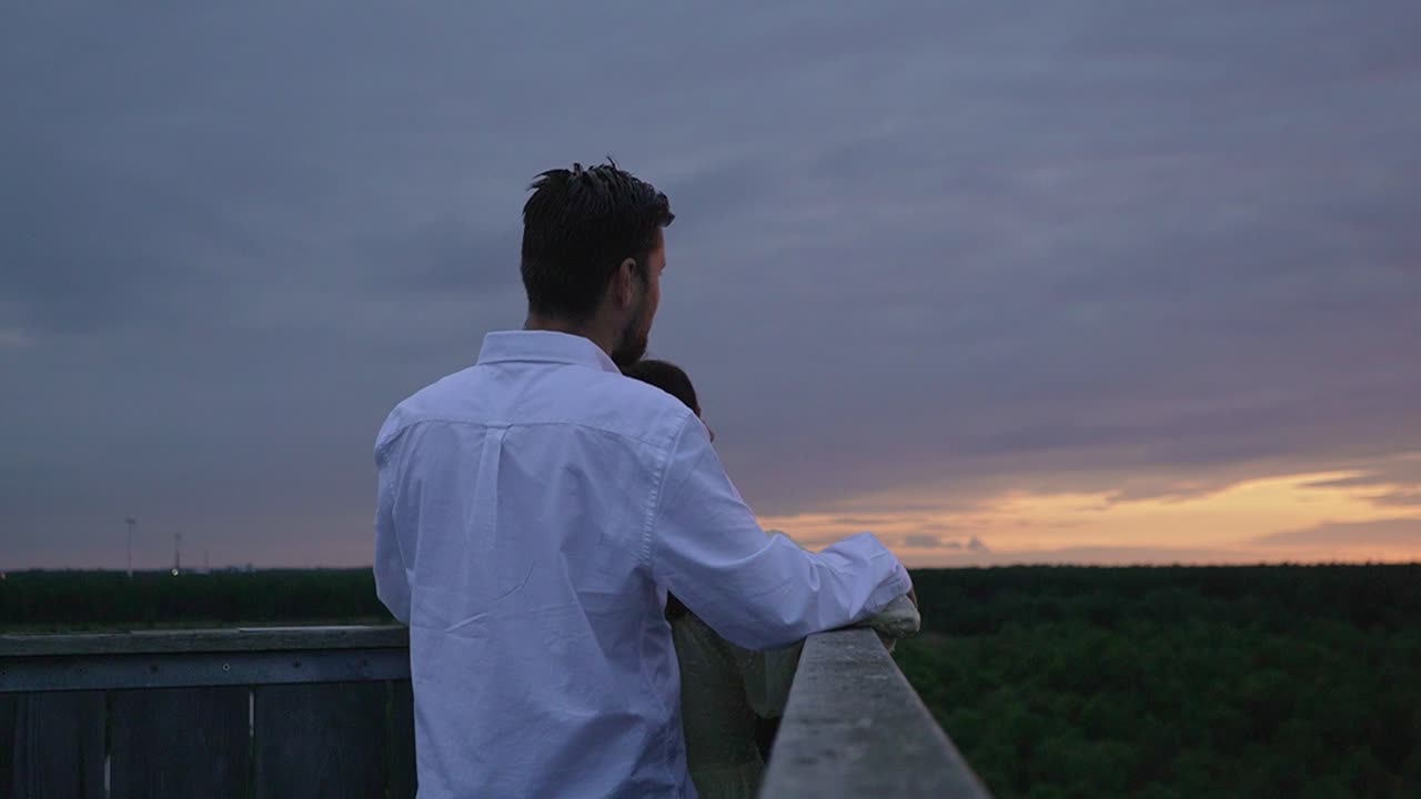 Husband hugging his wife from behind on a look out spot.