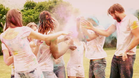 in slow motion happy friends throwing powder paint