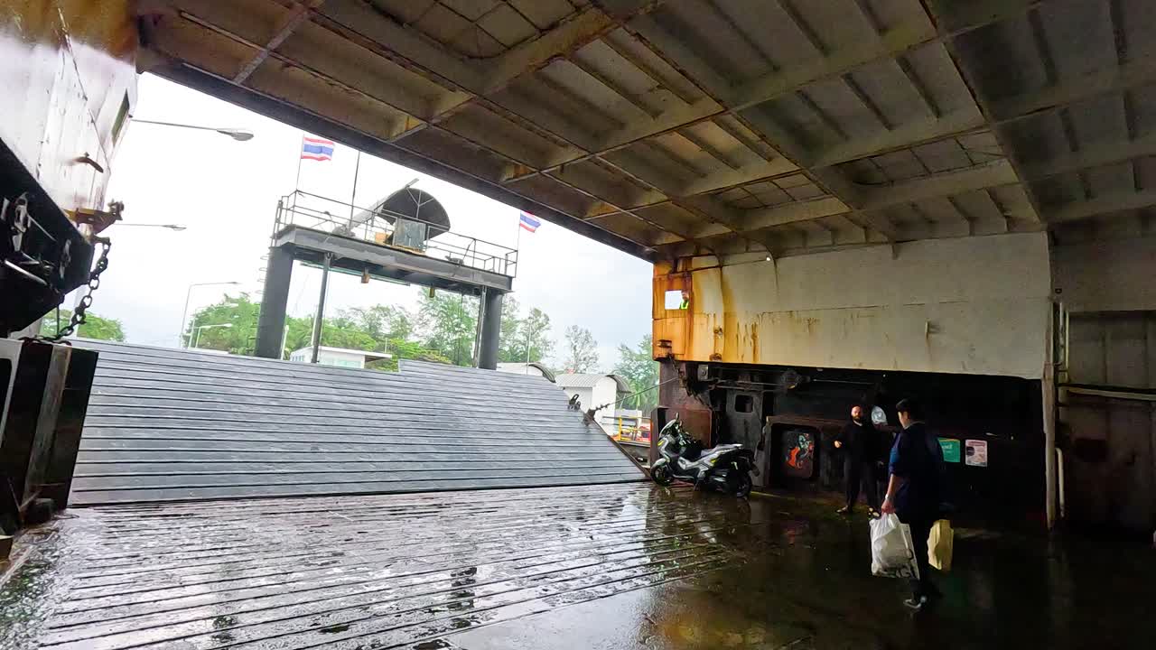 Passengers disembark from ferry onto wet dock