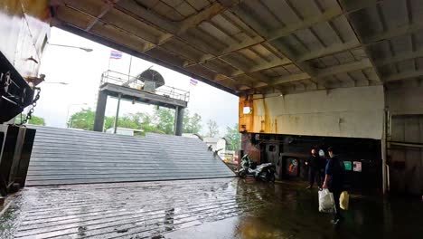 passengers disembark from ferry onto wet dock