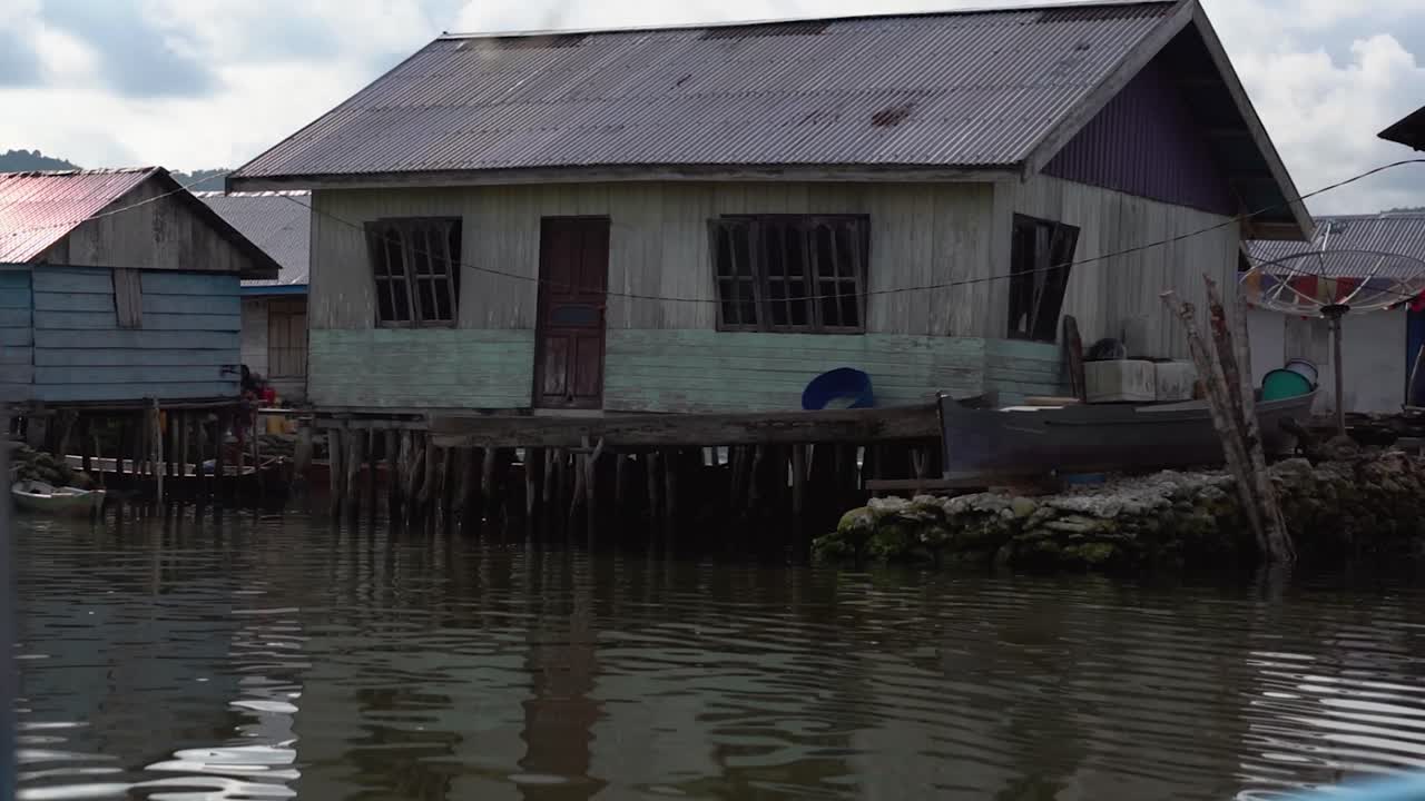 4k camera video from a boat sailing through the Bajau Village, known as the Bajau Tribe or Sea Gypsies who live a unique lifestyle in the Banggai Islands, in Sulawesi Indonesia