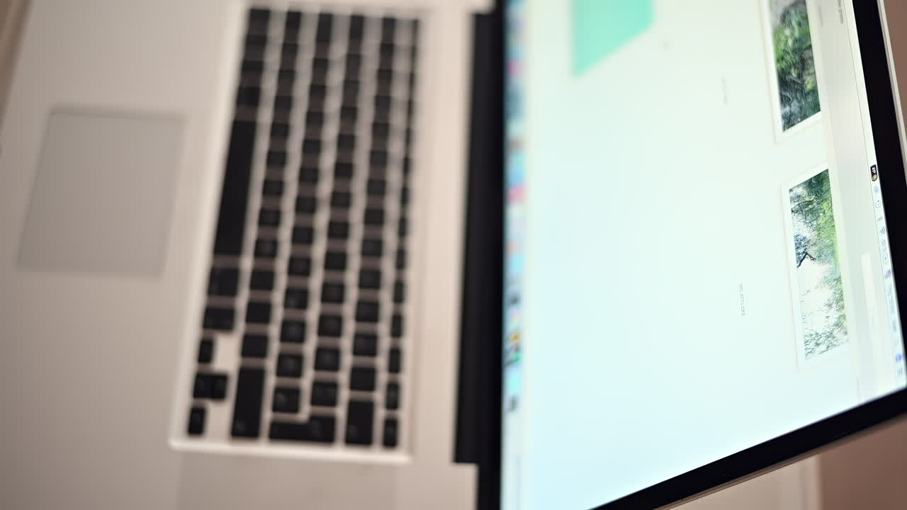 A laptop is set up on a wooden surface, showcasing a creative project on the screen. Natural light illuminates the workspace, creating a productive atmosphere for work