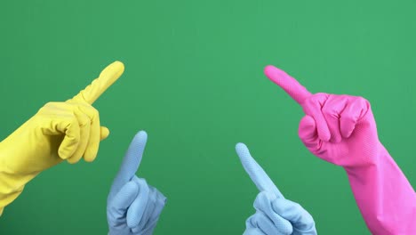 many hands with protective rubber gloves rise up and fingers point upwards over empty chroma key green screen background. hand gesture. 4 k video