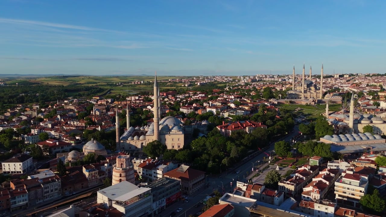 Edirne, Türkiye'nin şehir silüetinin üzerinde yükselen tarihi camileri ve minareleri gösteren panoramik drone çekimi. Geleneksel Osmanlı mimari yapılarını yakalayan muhteşem bir hava manzarası.