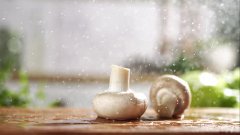 cámara lenta de champiñones blancos y marrones cayendo sobre una tabla de madera mojada en una cocina