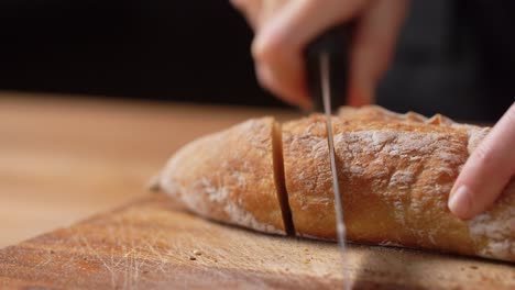 Panadera-Cortando-Pan-Casero-En-La-Panadería.-Concepto-De-Cocina,-Repostería-Y-Personas:-Panadera-Con-Cuchillo-Cortando-Pan-En-Rebanadas-En-La-Panadería-O-La-Cocina