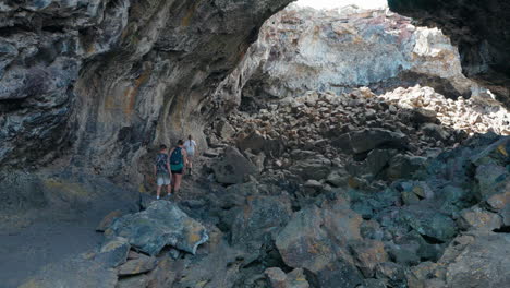 people exploring a rocky lava tube cave