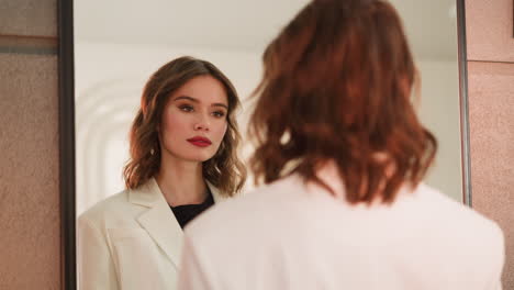 Elegant-lady-with-bright-makeup-enjoys-looking-in-mirror