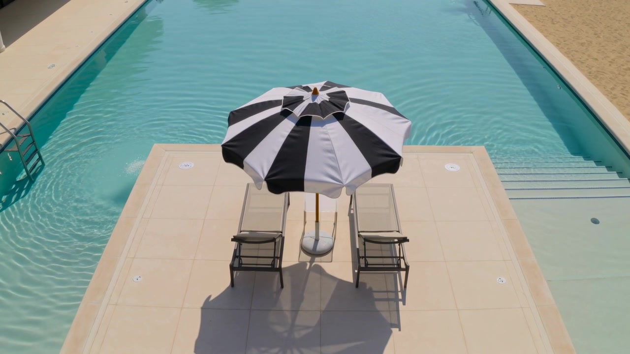 Camera tightening, umbrella and chaises rotating on pool platform as breeze causing ripples, shadow