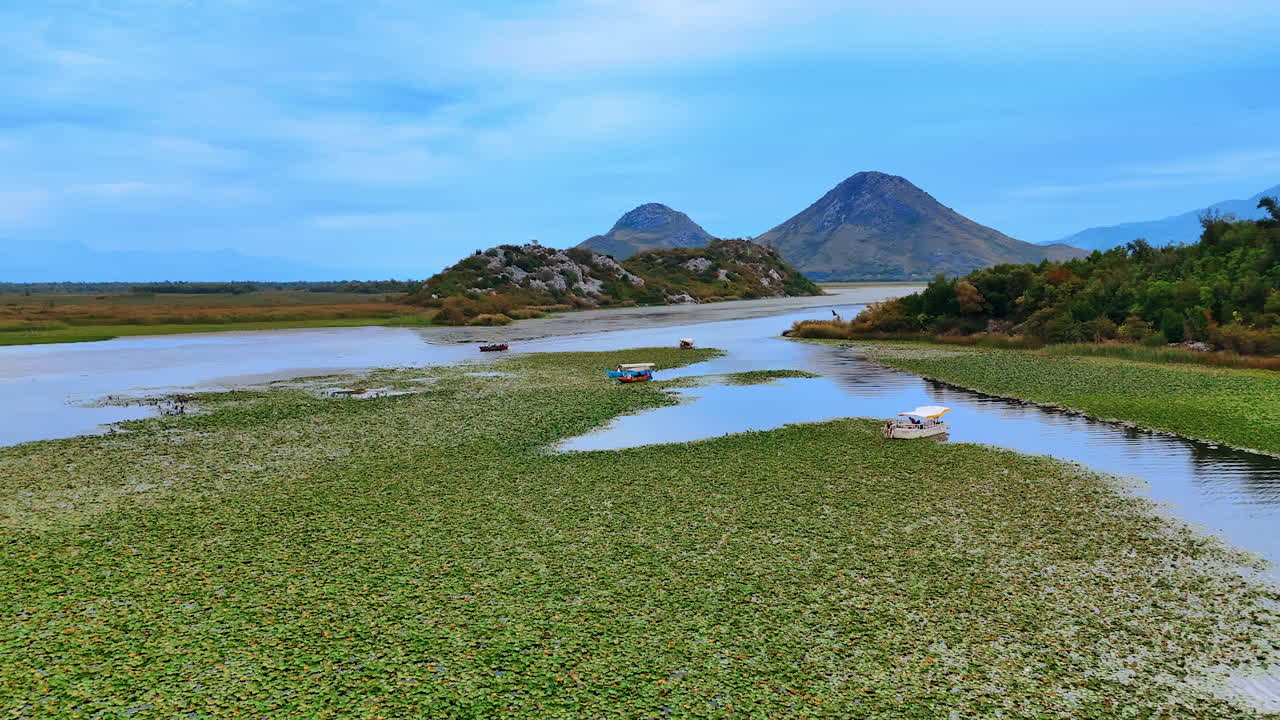 Ulcinj, Montenegro, 14 August 2025: Boats on Lily Channel. Colorful boats float through a lily covered channel in the wetlands