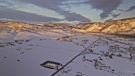 Oakley-Utah-Vista-Aérea-V2-Panorámica-Vista-Aérea-De-Drones-Sobre-El-área-De-La-Ciudad-Capturando-Prístinos-Campos-De-Nieve-Y-Una-Hermosa-Puesta-De-Sol-Dorada-Brillando-En-Las-Cadenas-Montañosas---Filmada-Con-Cine-Mavic-3---Febrero-De-2023