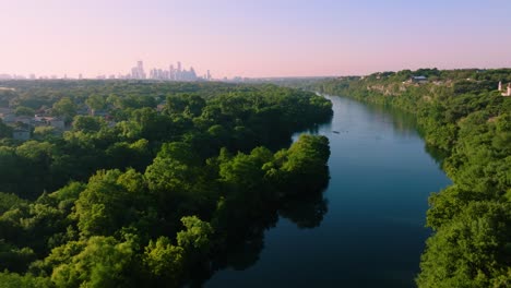 Aerial-sweep-of-Redbud-Isle-nature-trail-in-Austin,-Texas-during-hazy-summer-sunrise-in-2022-with-4k-drone-over-Town-Lake