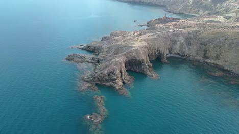 an aerial view reveals the haunting ruins of an abandoned iron mine and a deteriorated port by the sea