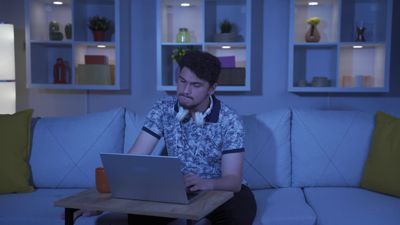 Unhappy man using laptop laptop at night. It's not in a good mood.