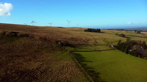 aerial shot of wind turbines in a field in northern ireland on a sunny day
