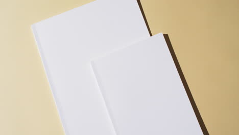 Video-of-books-with-blank-white-pages-and-copy-space-on-yellow-background