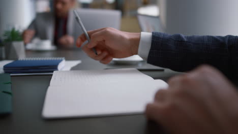 ceo filling form document in office with business partner. man hand write paper.