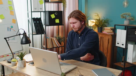 upset business man feeling stomach ache overeating during work process on laptop in home office