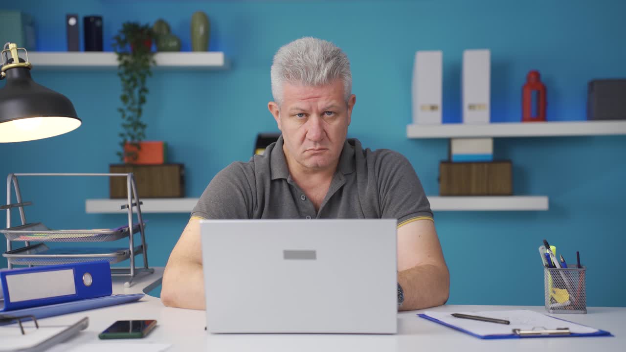 Homeoffice-Mitarbeiter blickt mit Angst und Zweifel in die Kamera