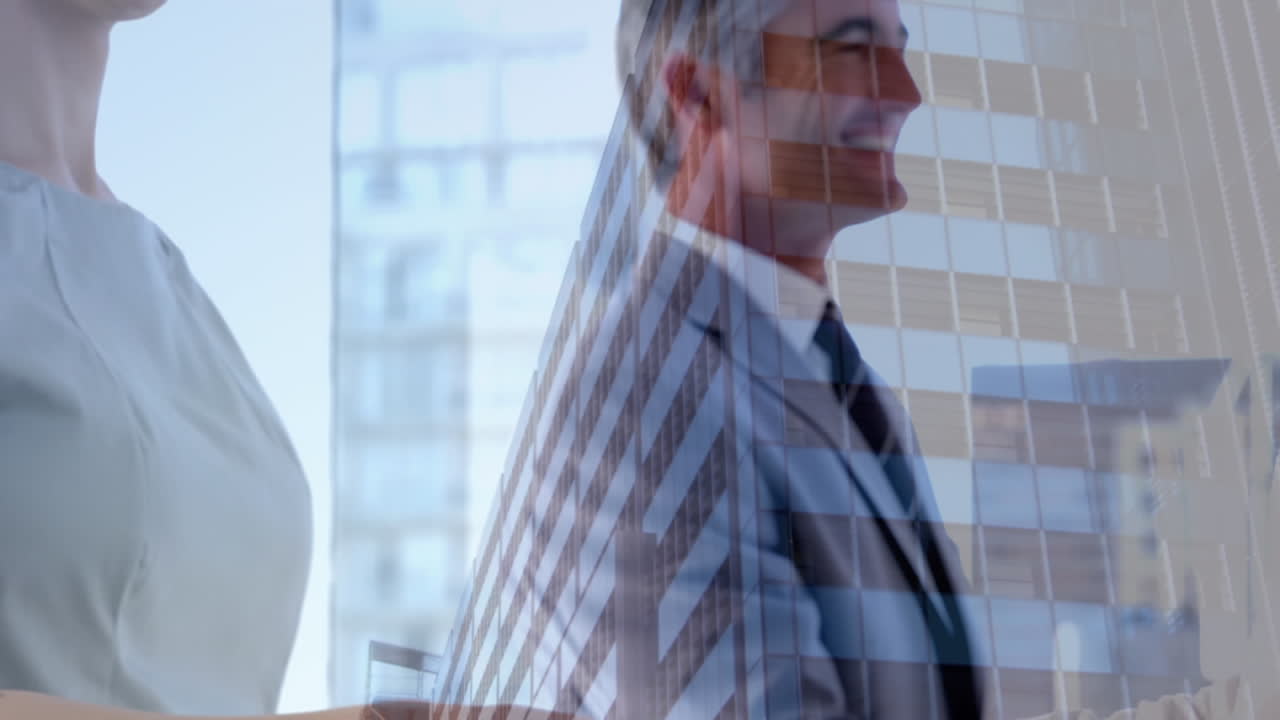 Mid section of businessman and businesswoman shaking hands at office against tall buildings