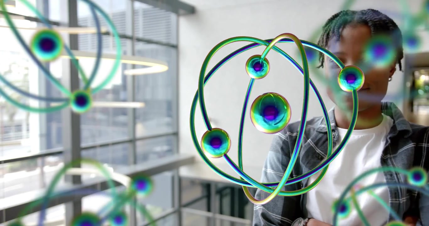 Man standing atrium experiencing atom emergence, examining rotating science holograms curiously