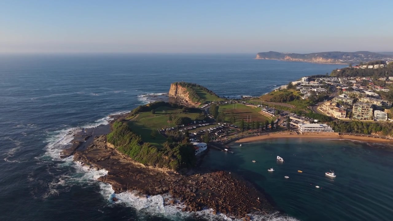 Il promontorio di Terrigal Haven e la baia riparata incontrano il Pacifico all'alba, ripresa aerea con drone in avvicinamento