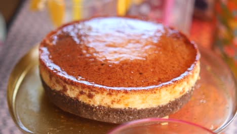 close up of a caramel cake on a glass plate