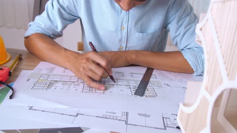male architect working on a building blueprint
