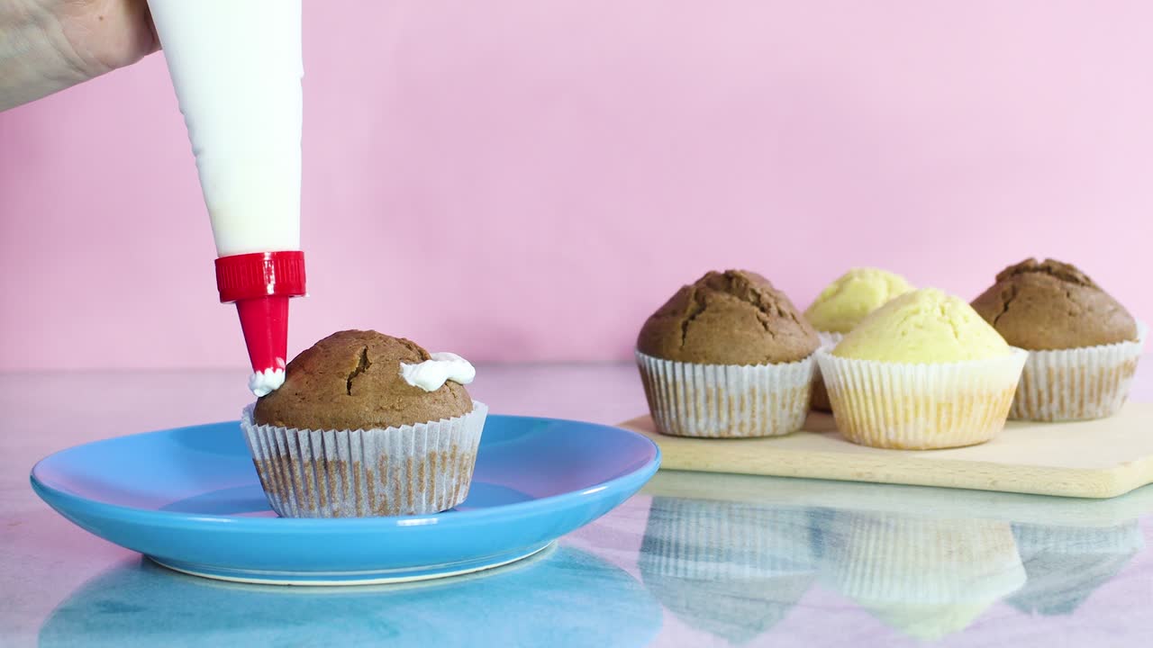 Decorating delicious chocolate cup cake with white cream