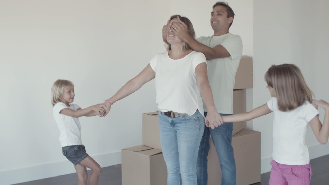 Dos niñas dulces y su papá guiando a mamá con los ojos cerrados