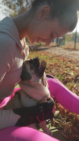 woman and pug enjoying time in autumn park