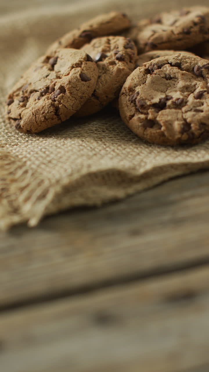 video vertical de galletas de chispas de chocolate en tela y fondo de madera
