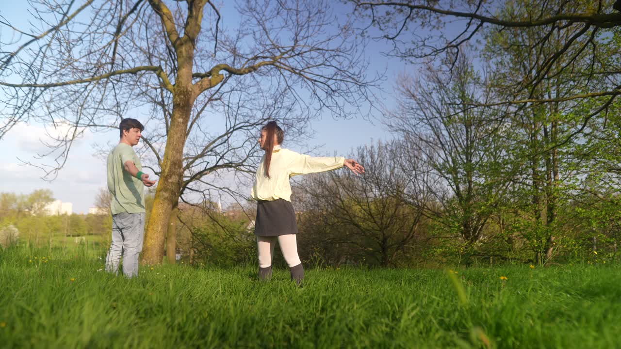 Couple dancing in a park on a sunny day