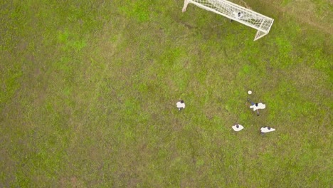 bird's eye view of boys playing football in tanzania - drone shot