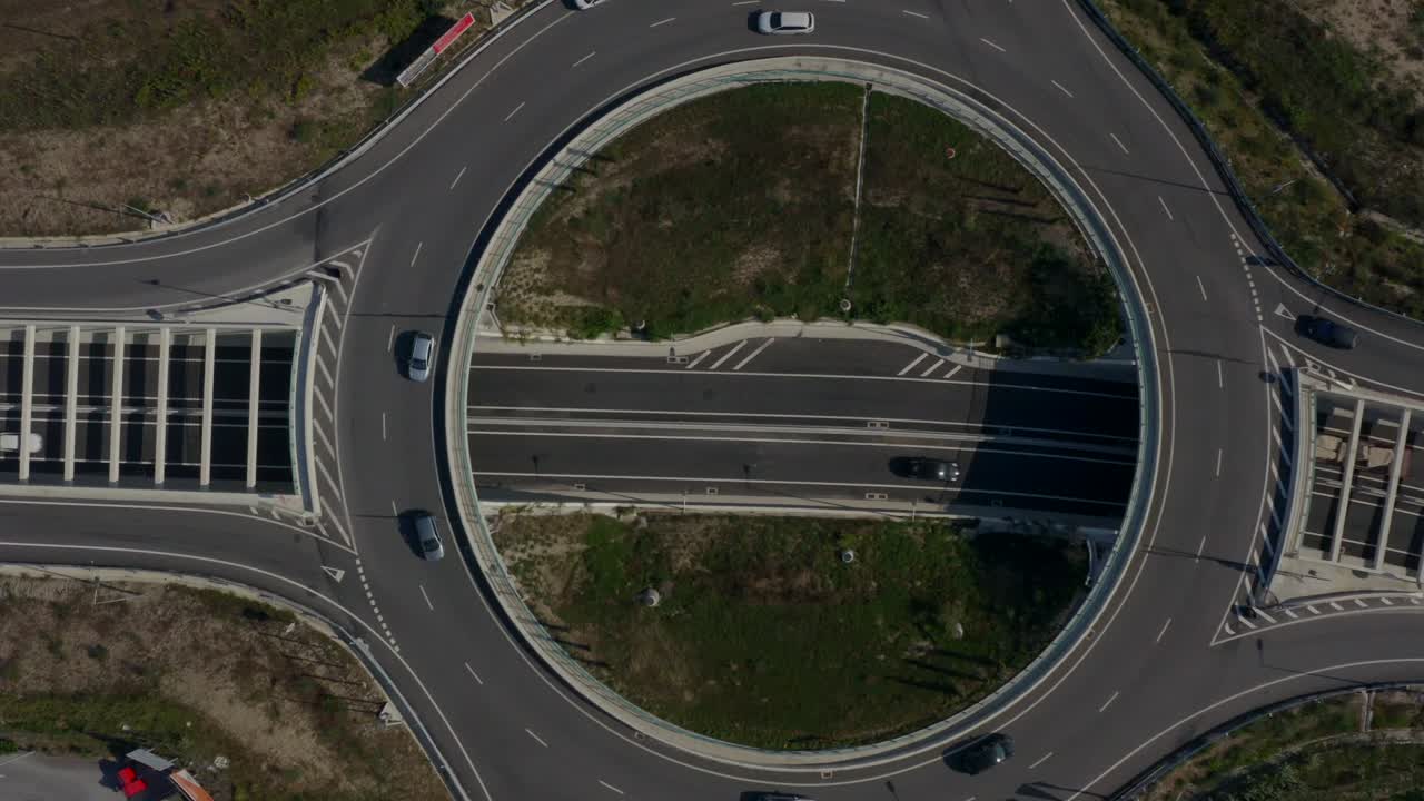 Cars passing by on a highway with a roundabout.