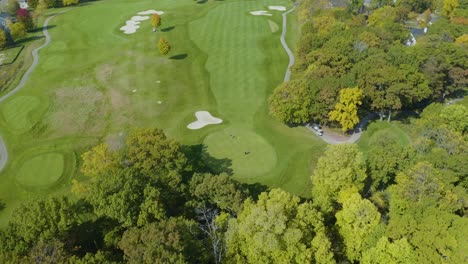 top down aerial view of golf players teeing off at golf club