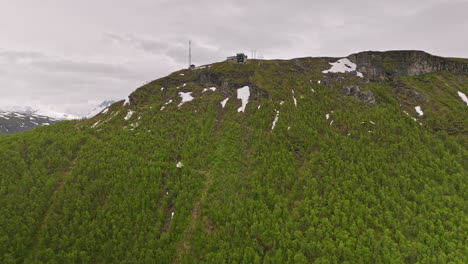 tromsø noruega drone aéreo v14 cinematográfico vuela lentamente hasta la cornisa de la montaña del monte storsteinen, vista de pájaro con vistas a la estación de teleférico fjellheisen - filmado con cine mavic 3 - junio de 2022