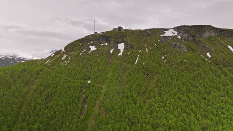 tromsø norway aerial v14 cinematic drone slowly fly up to the mountain ledge of mount storsteinen, birds eye view overlooking at fjellheisen cable car station - shot with mavic 3 cine - june 2022