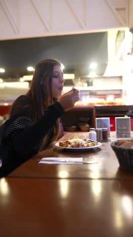 una mujer cenando en un restaurante.