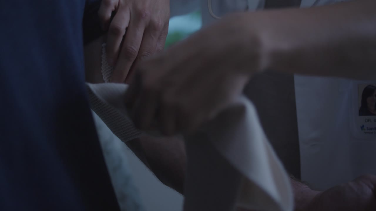 The doctor puts a bandage on the patient's arm due to a sprained muscle