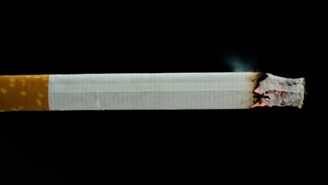 Burning-cigarette-on-black-background-in-reverse