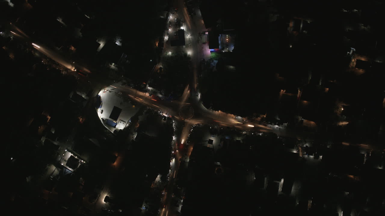 Close top down aerial hyperlapse of busy intersection in Bo, Sierra Leone at night.