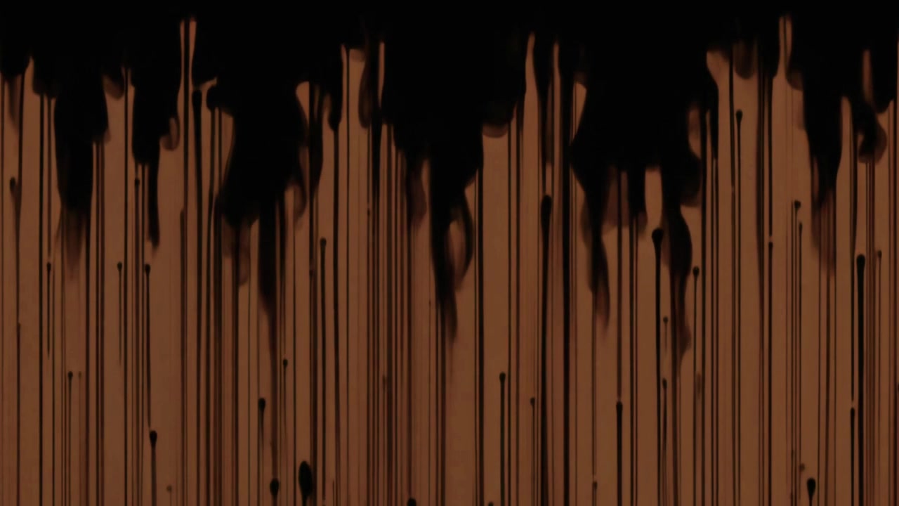 Inchiostro nero che gocciola su uno sfondo marrone